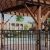a covered area with a fence and buildings in the background