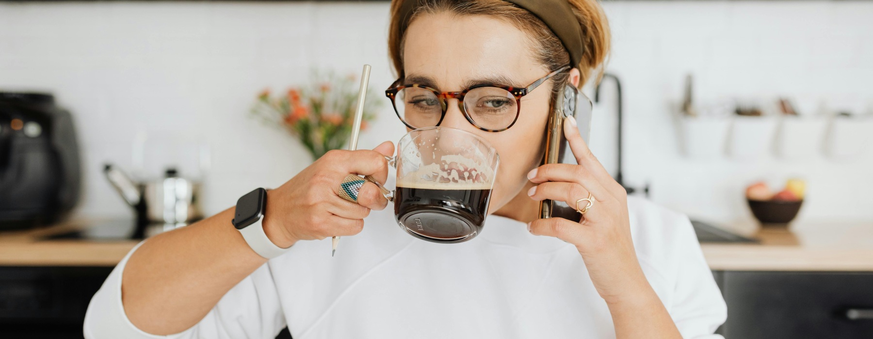 a woman on the phone drinking a cup of coffee