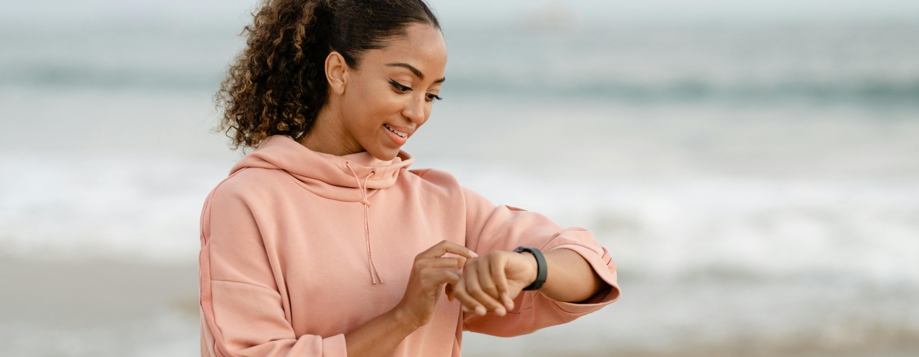 a woman checking her watch on the beach